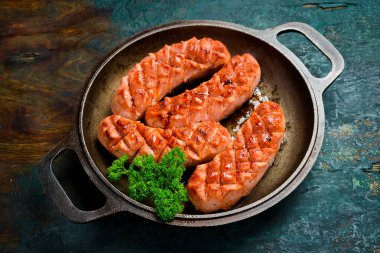 Dökme demir tavada kızarmış tavuk sosisi. Ev yapımı yemek. Üst görünüm.