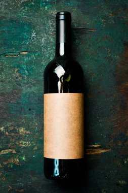 Masadaki şişede kırmızı şarap, mesaj için boş yer. Şişe içinde yıllanmış şarap. Üst görünüm.
