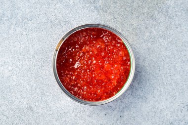 Bir kavanoz kırmızı somon havyarı. Ürünler Omega-3 açısından zengindir. Lezzetli deniz ürünleri atıştırmalıkları. Gri beton arka planda.