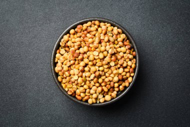 Soya fasulyeli siyah taş kâse. Kuru fasulye tohumu. Siyah taştan bir arka planda.