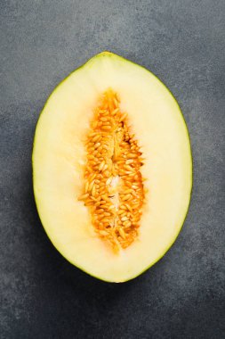 Taze olgun ve tatlı kavun. Taş bir masada yarım bir kavun. Üst görünüm.