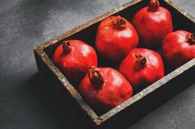 Tepside olgun nar meyveleri var. Kırsal tarzda. Yaratıcı meyve fotoğrafı.