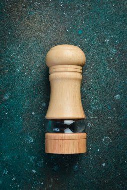 Tuz için ahşap değirmeni. Koyu yeşil turkuaz bir arka planda. Metin için boş alan.