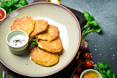 Ekşi kremalı kızarmış patates gözlemesi. Ukrayna mutfağı. Kapatın. Karanlık bir taş arka planda.