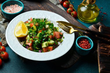 Zeytin yağı ve limonlu taze sebze salatası. Beyaz bir tabakta. Metin için boş alan.