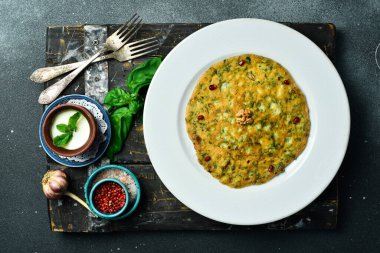 Yeşil ve tuzlu yoğurtlu geleneksel Azerbaycan krepi. Metin için boş alan. Karanlık bir arka planda.