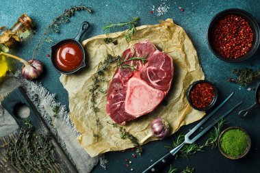 Biberiyeli çiğ ossobuco bifteği ve siyah taşlı arka planda baharatlar. Metin için boş alan.