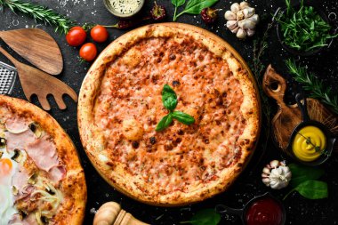 Pizza margherita. Siyah taşlı arka planda klasik pizza. Üst görünüm.