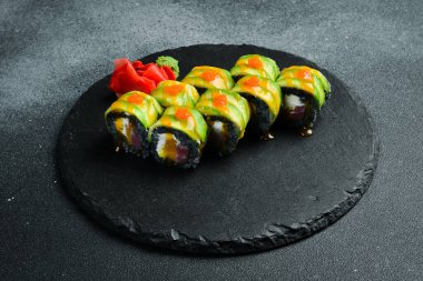 Siyah pirinçli suşi, siyah arka planda balık ve avokado. Suşi, nigiri, maki, zencefil turşusu, wasabi, soya sosu. Suşi masada hazır..