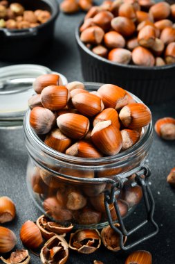 Cam kavanozdaki organik fındıklar. Yan görüş. Fındık yığını dolu. Kapat..