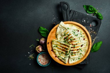 Geleneksel Azerbaijan mutfağı. Otlar ve etle birlikte düz ekmek. Kutaby qutab kutab. Metin için boş alan. Karanlık bir arka planda.