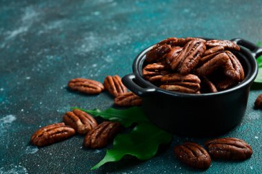 Fındık. Kavanozda karamelli ceviz. Yan görüş. Karanlık bir arka planda.