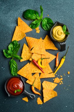 Baharatlı tortilla cipsi, domates sosu ve fesleğen. Mısır cipsi. Üst görünüm.