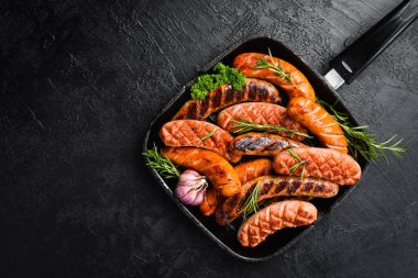 Domuz eti, sığır eti ve tavuk sosisi ile ızgara. Üst Manzara, kapat. Siyah taştan bir arka planda.