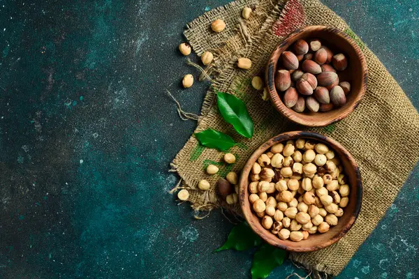 Tahta bir kasede fındık. Sağlıklı atıştırmalıklar. Üst Manzara. Karanlık bir arka planda.