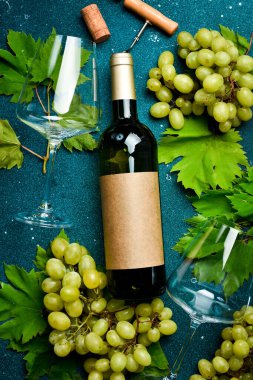Bir şişe şarap, taze üzüm, tirbuşon ve şarap mantarı. Şarap bardakları. Üst görünüm.