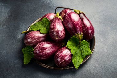 Organik patlıcanlı metal tepsi. Yan görüş. Gri beton arka planda.