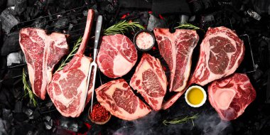 Açık ateşte pişirilmiş büyük bir et seti. Barbekü. Tomahawk bifteği, Ribeye, Ossobuco ve biftek..