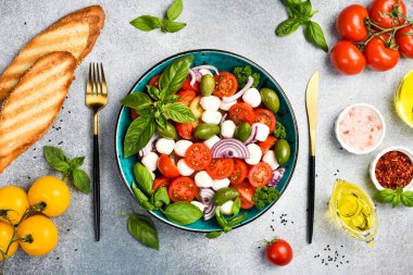 Bir kasede renkli salata: domates, mozzarella peyniri, fesleğen ve zeytin. Üst görünüm.