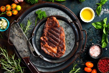 Biftek. Biberiyeli ızgara biftek ve metal tabakta baharat. Üst görünüm.
