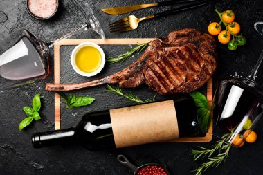 Şişe şarap, bardaklar ve biftek. Siyah Angus bifteği ve yıllanmış şarap. Üst görünüm.