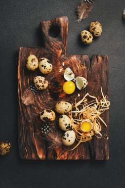 Quail eggs on a wooden board. Rustic style. Top view. clipart