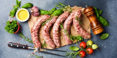 Parşömen kağıdında taze et sosisi, baharat ve biberiye, ızgaraya hazır. Üst görünüm.