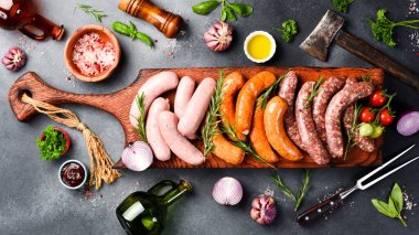 Büyük boy barbekü sosisi: sığır eti, domuz eti ve tavuk sosisi. Tahta kesme tahtasının üzerinde. Üst görünüm.