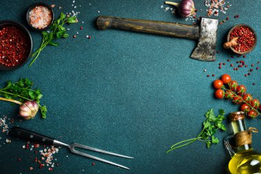 Menü sayfası için pankart. Mutfak masasında sebzeler, baharatlar ve mutfak aletleri var. Karanlık bir arka planda. Üst Manzara. Metin için boş alan.