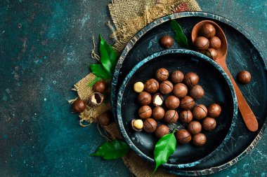 Arka planda ahşap kasede Macadamia fındıkları. Uzayı kopyala Süper yiyecek, vegan, vejetaryen gıda konsepti. Sağlıklı atıştırmalık..