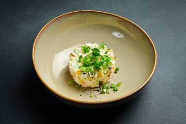 Yengeç çubuklu salata, mısır, soğan ve mayonez. Siyah taştan bir arka planda. Metin için boş alan.