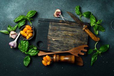 Sonbahar aşçılık geçmişi: sarı domates, fesleğen, baharat ve mutfak kesme tahtası. Organik yiyecekler. Üst görünüm.