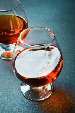Eskimiş bir konyak ya da karanlık bir masada konyak. Güçlü alkollü içecekler. Beton bir arka planda.