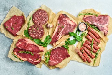 Et arka planı. Biftek, kebap, pirzola ve dana eti. Et ürünleri. Gri taştan bir arka planda. Üst görünüm.