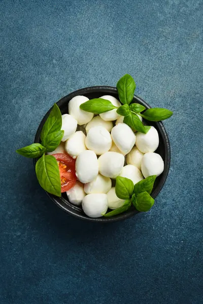 Caprese salatası yapmak için gerekli malzemeler. Domatesli, fesleğenli ve yağlı Mozzarella peyniri topları..