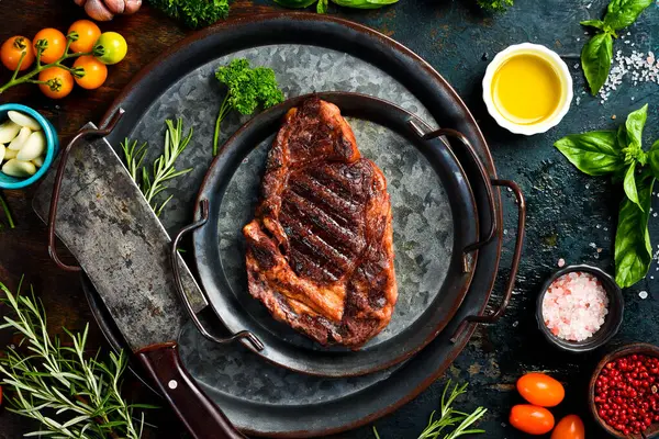 Biftek. Biberiyeli ızgara biftek ve metal tabakta baharat. Üst görünüm.