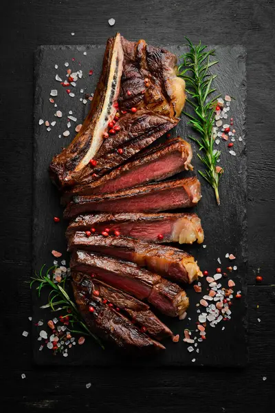 Angus bifteği. Biberiye ve tereyağlı dilimlenmiş biftek. Üst görünüm.