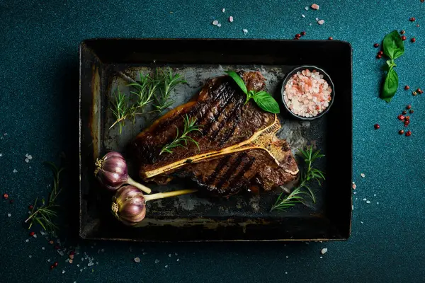 Sağlıklı yağsız, orta pişmiş biftek. Metal bir tencerede biftek. Biberiye ve baharatlar.