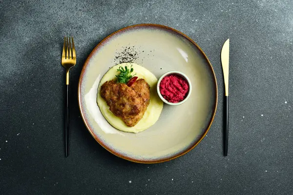 Domuz pirzolası ve pancar soslu patates püresi. Ev yapımı yemek. Karanlık bir taş arka planda.