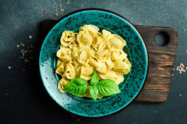 Ev yapımı pelmeni, ravioli, tereyağı soslu etli börek ve fesleğen. Üst görünüm.