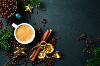Masada bir fincan kahve ve yılbaşı süslemeleri. Üst görünüm, siyah arkaplan, bedava kopya alanı. Tatil.