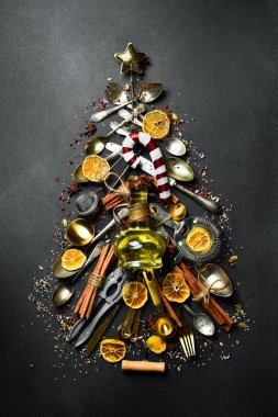 Noel kartı. Mutfak aksesuarlarından yapılmış Noel ağacı. Karanlık bir arka planda. Üst görünüm.
