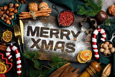 Mutlu Noeller - Mutfak Noel yemekleri arka planında bir yazı var. Yeni yıl ve Noel süsleri ve mutfak aletleri. Üst Manzara. Düz yatıyordu.