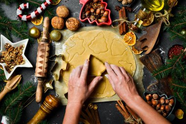 Noel pişirme konsepti. Kadın eli hamurdan kurabiye keser. Zencefilli ekmek pişirmek için gerekli malzemeler.