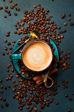 Bir fincan kapuçino ve kahve çekirdeği. Üst görünüm, siyah arkaplan, bedava kopya alanı. Robusta veya Arabica.