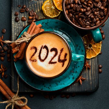 Numara 2024. Tarçınlı kapuçino. Yeni yıl dekoru. Karanlık bir arka planda.