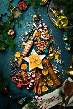 Eski mutfak malzemelerinden, baharatlardan, tatlılardan ve çatallardan yapılmış Noel ağacı. Karanlık bir arka planda. Üst görünüm.