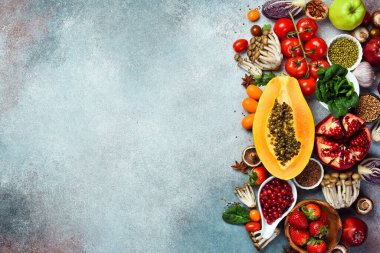 Meyveler, böğürtlenler, sebzeler ve fındıklar: papaya, brokoli, narenciye, domates ve ıspanak yaprakları. Sağlıklı yemek..