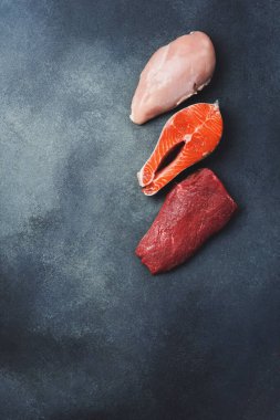 Bir çift çiğ biftek: sığır eti, balık ve tavuk eti. Üst Manzara. Sağlıklı yemek..