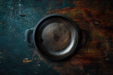 Tahta bir masada metal dökme demir tava. Metin için boş alan. Üst görünüm.